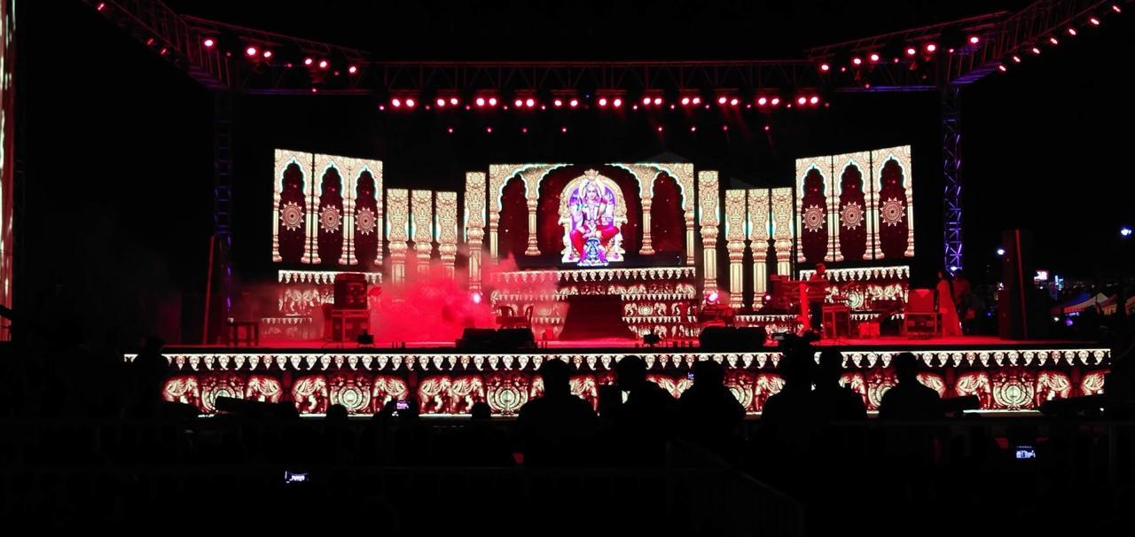Religious cultural event with ornate temple-style LED stage design and red lighting in Karnataka