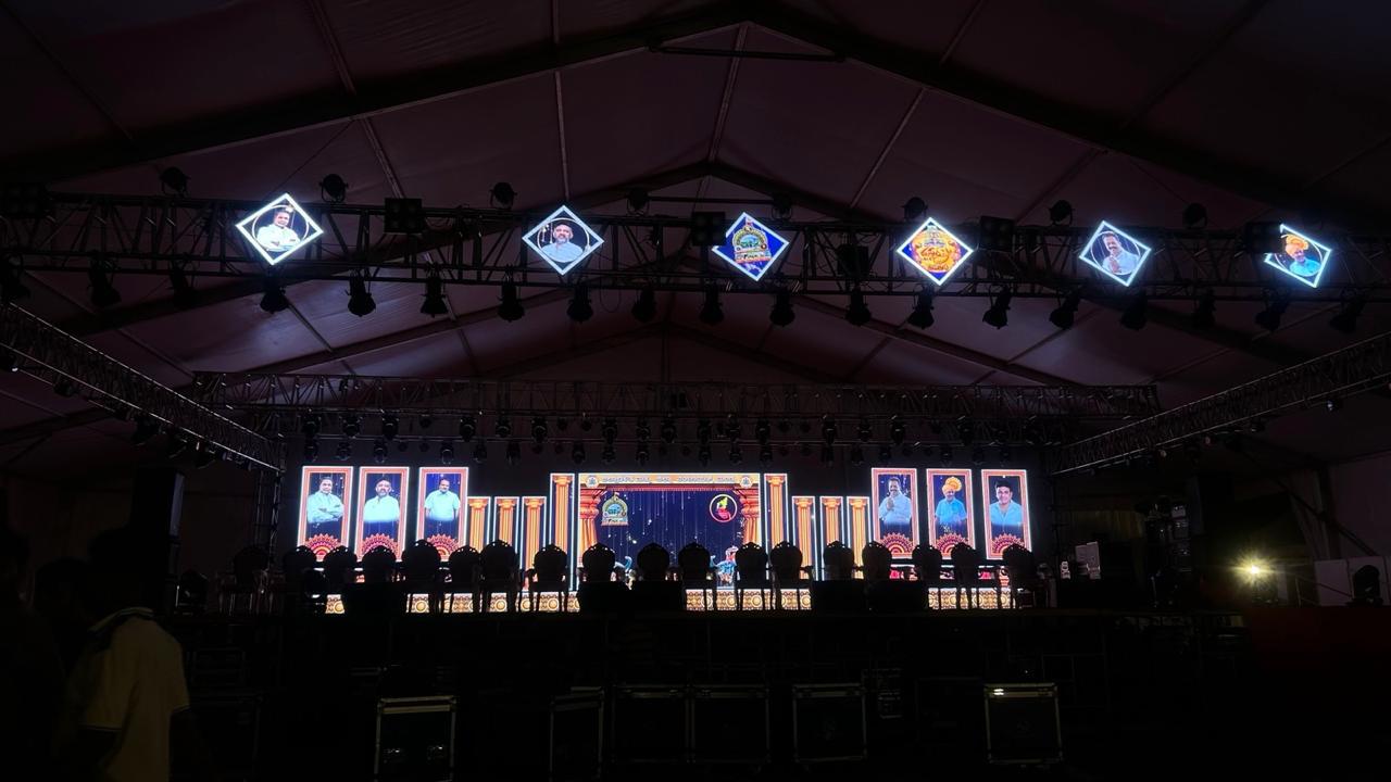 Outdoor cultural event with diamond-shaped LED screens on truss and stage lighting in Karnataka