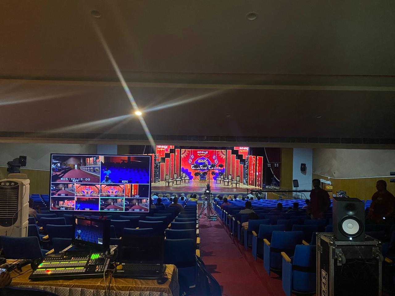 Indoor auditorium with multi-camera video production setup, mixing console, and LED stage in Bangalore