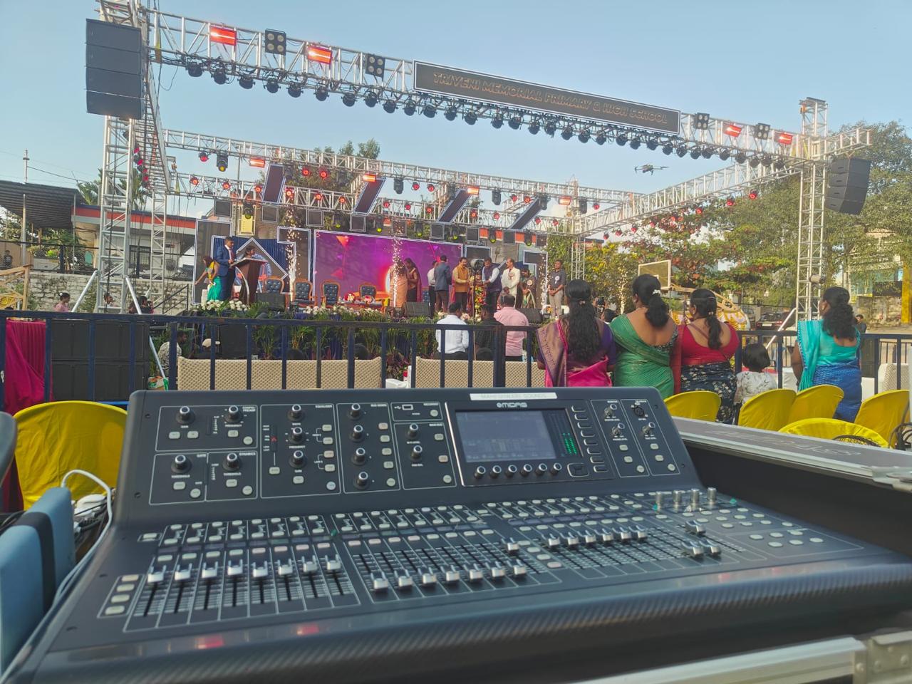 Professional sound mixing console at outdoor event with stage and PA system by Supreme Media Productions