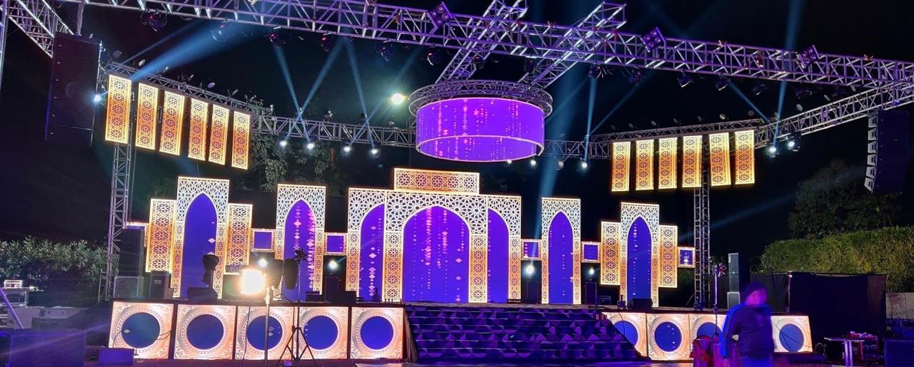 Grand outdoor event stage with Mughal-arch LED panels, purple and gold lighting, and truss rigging in Bangalore
