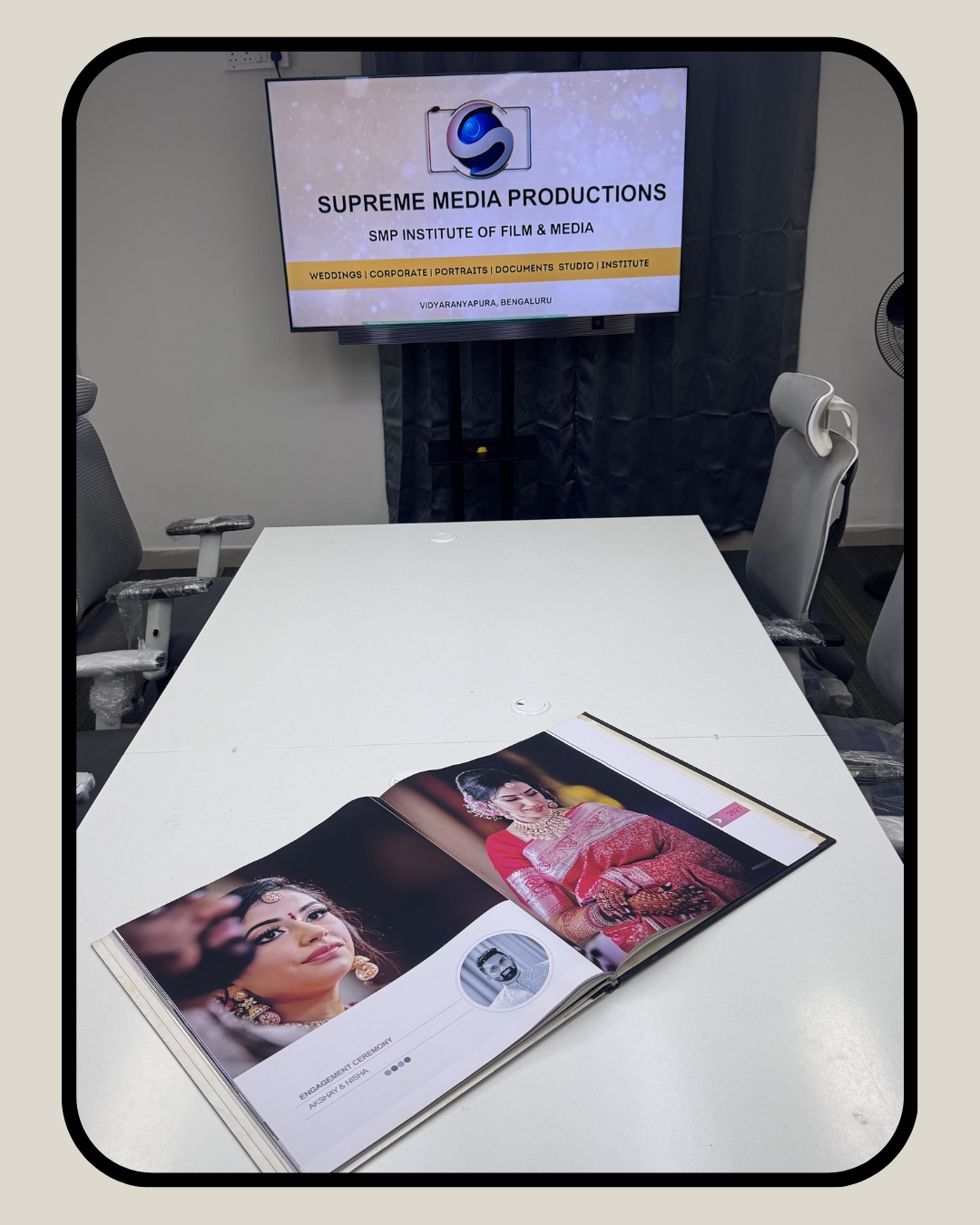 Production desk with portfolio album and SMP branding screen at Vidyaranyapura studio