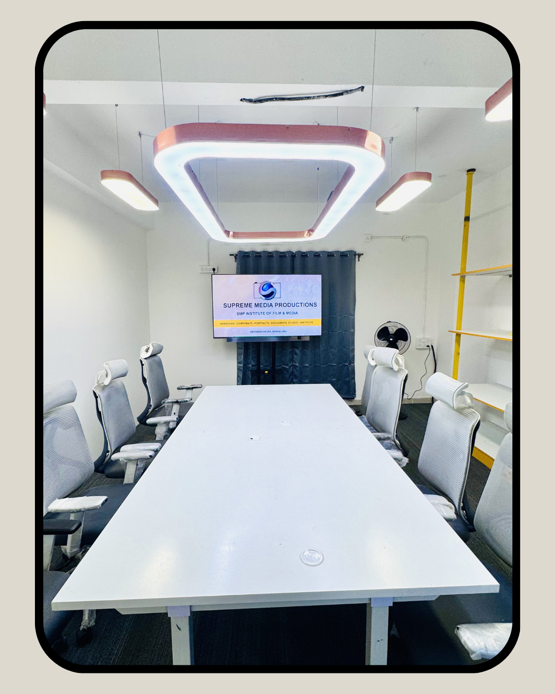 Client meeting room frontal view with Supreme Media Productions branding on display screen